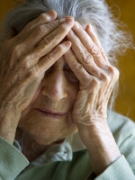 Elderly woman with hands over face